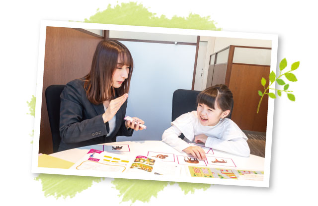 ジェスチャーをしながら話す小学生とそれを聞く講師